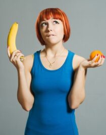 red-haired-girl-with-banana-orange_1385-2896